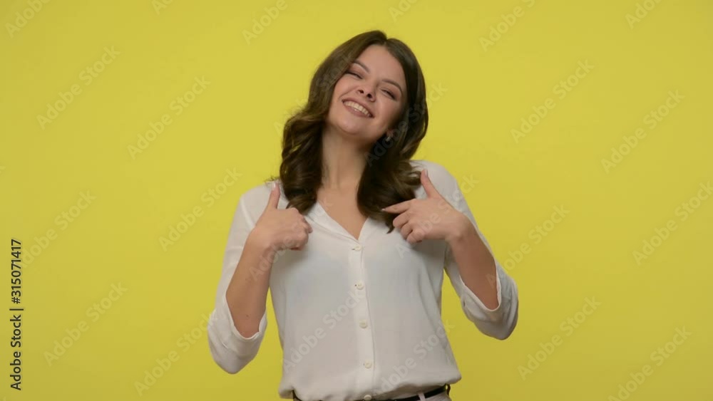 This is me! Attractive successful woman with brunette hair in blouse pointing herself and grinning happily, looking boastful proud of personal achievements. studio shot isolated on yellow background This is me! Attractive successful woman with brunette hair in blouse pointing herself and grinning happily, looking boastful proud of personal achievements. studio shot isolated on yellow background
