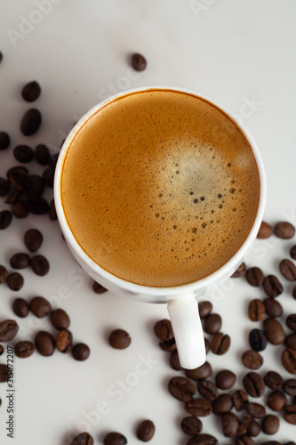 cup of coffee with beans on white background close up