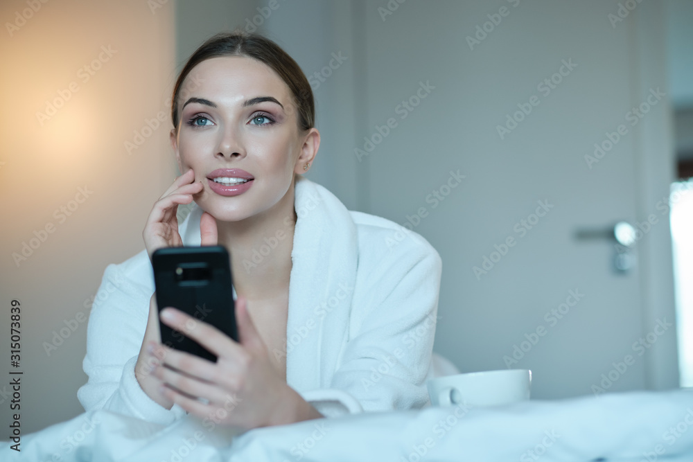 The girl in bed. She looks at the smartphone. Influence of social networks on youth. The girl in bed. She looks at the smartphone. Influence of social networks on youth.