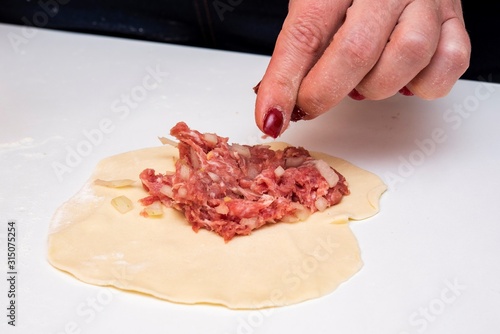 cooking meat pies with female hands
