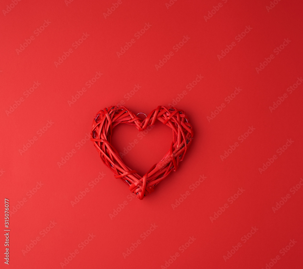 red wicker decorative heart on a red paper background red wicker decorative heart on a red paper background