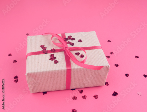 box wrapped in brown kraft paper and tied with red thin silk ribbon