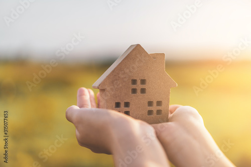 Small home model on woman hand.