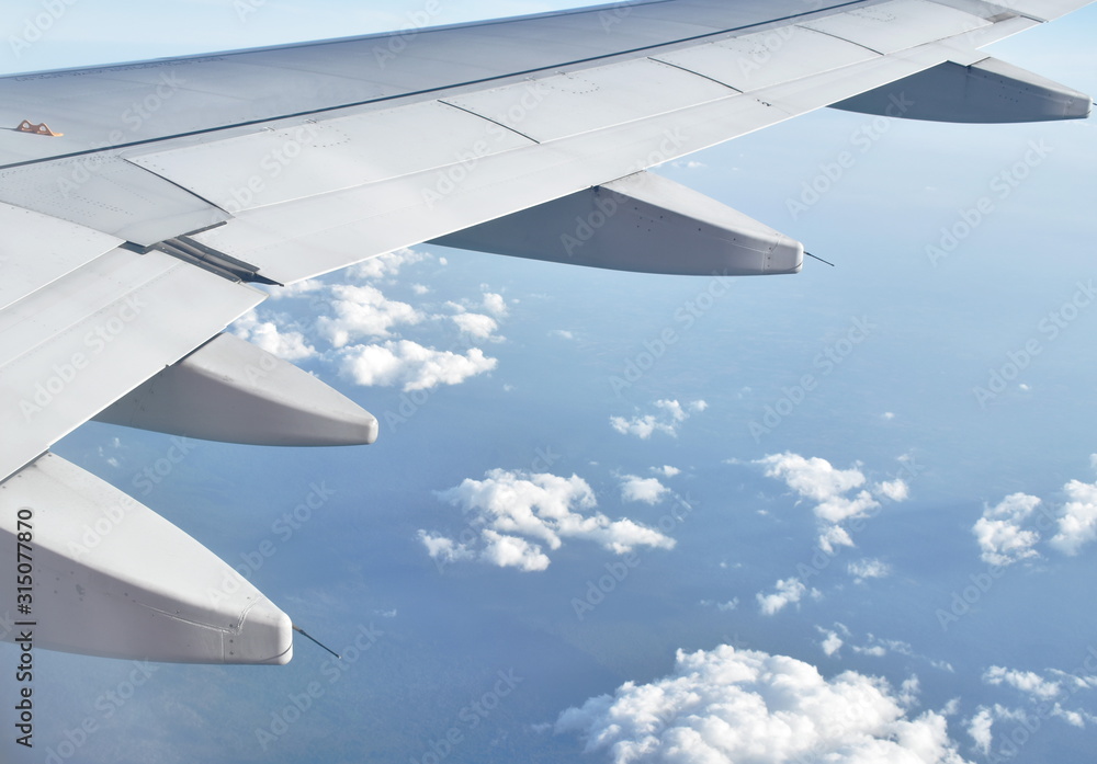 Obraz premium plane wing and cloud floating on sky through window frame