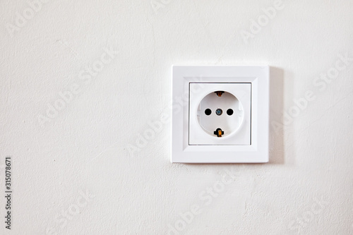 Electrical outlet socket on the white wall