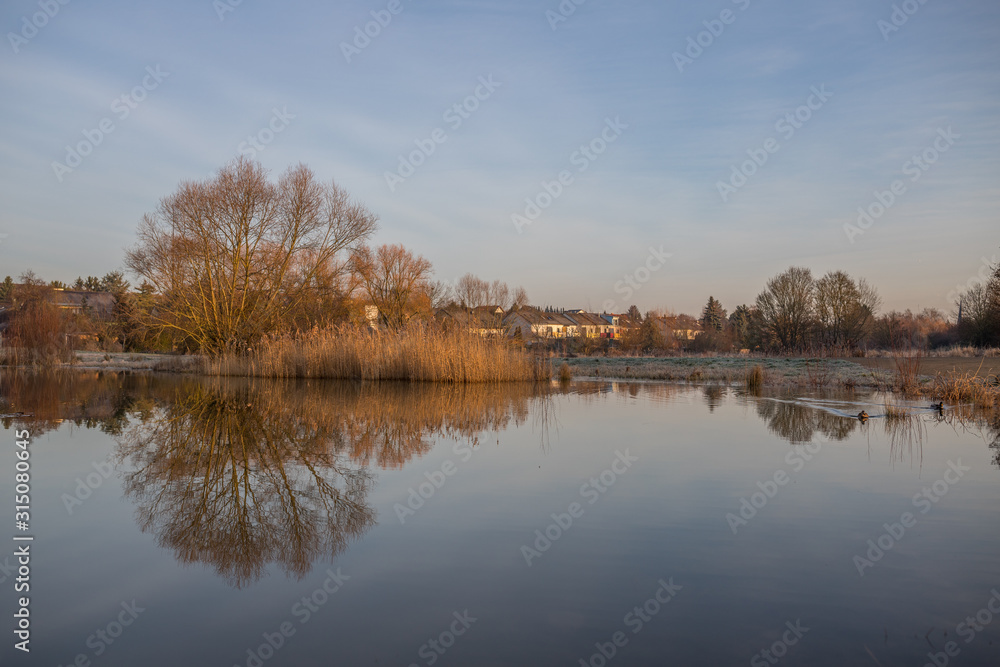 Sonnenaufgang über einem kleinen See an einem Wintermorgen