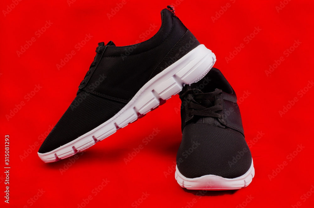 Pair of new unbranded black sport running shoes or sneakers isolated on red  background with clipping path Stock Photo | Adobe Stock