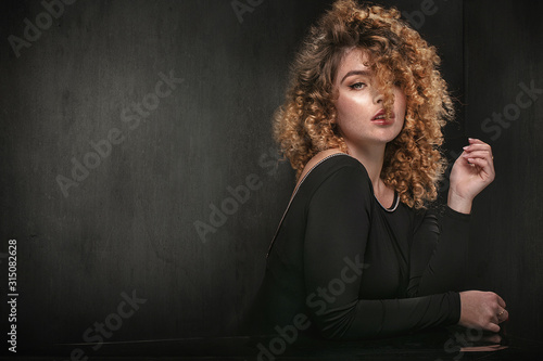 Elegant woman with curly hair posing.