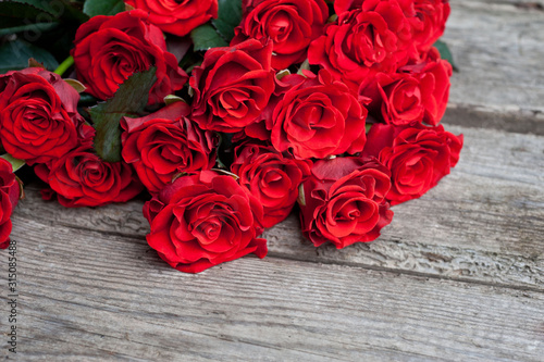 Bouquet of red roses on wooden background. Birthday. Valentine s day. March 8. Mother s day. Greeting card. Wallpaper. Banner.