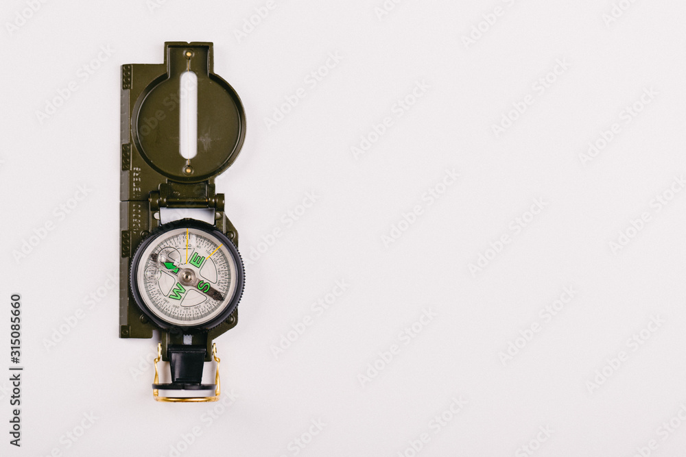 metal navigation travel compass on a light gray background. search for a way. point of view metal navigation travel compass on a light gray background. search for a way. point of view