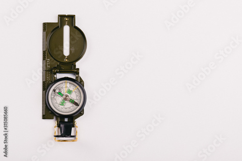 metal navigation travel compass on a light gray background. search for a way. point of view