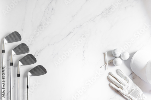 Golf equipment. The iron set and golf balls on marble background with copy space