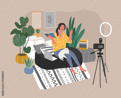 Young woman sitting in scandinavian interior and creating content for blog or live broadcasting. Teaching through internet or review book. DIY tutorial or webinar. Blogging or vlogging