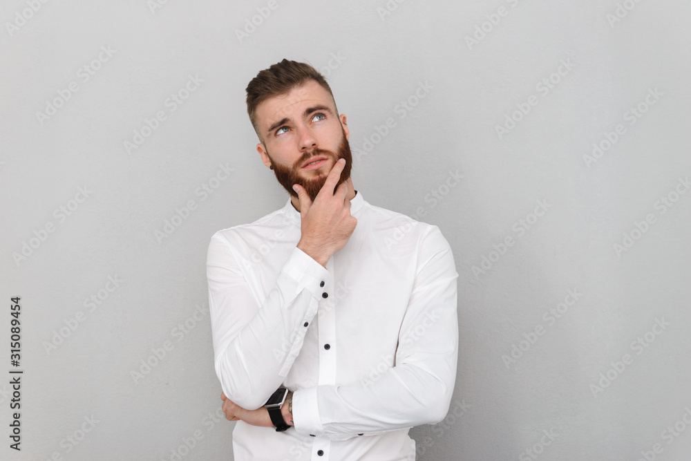 Image of bearded serious man looking upward and thinking Image of bearded serious man looking upward and thinking