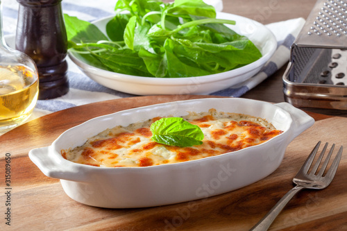 Baked spinach with cheese on a wooden background