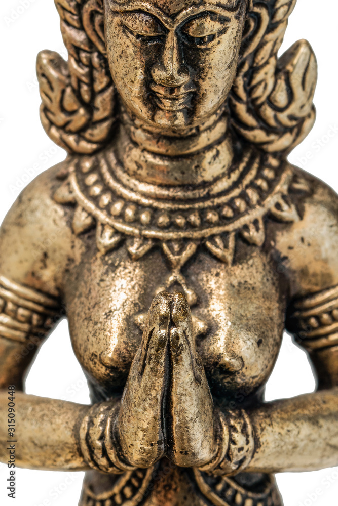 Eastern deity goddess fairy or angel praying with folded hands in front of his chest. bronze gold figurine close up Eastern deity goddess fairy or angel praying with folded hands in front of his chest. bronze gold figurine close up