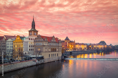 Historic buildings with the National Theater on the Vltava river bank at sunrise in Prague, Czech Republic, Europe.