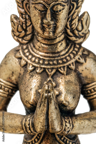 Eastern deity goddess fairy or angel praying with folded hands in front of his chest. bronze gold figurine close up