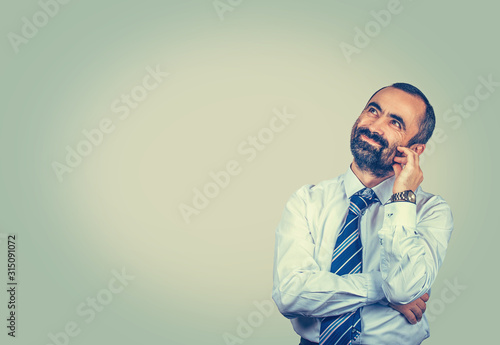 man looking up touch face with fingers daydreaming about future