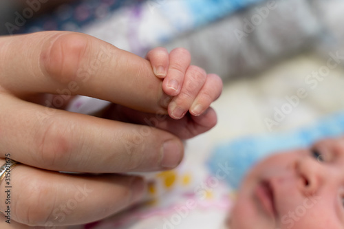 hands of a newborn baby and dad