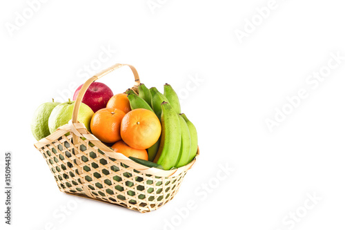 orange, guava, banana and apple in wicker basket on white background fruit health food isolated