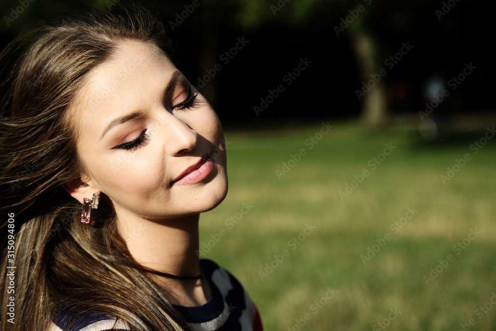 Outdoors portrait of a beautiful young woman smiling Outdoors portrait of a beautiful young woman smiling