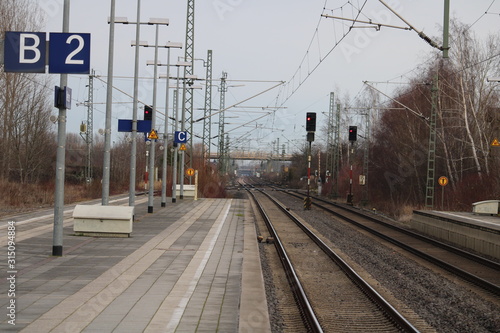 Platform and railroad tracks with bridge in the background