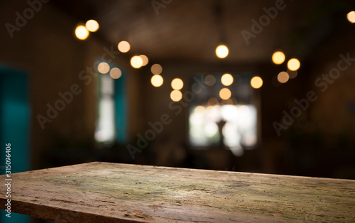 Obraz na płótnie Empty wood table top on blur light gold bokeh of cafe restaurant in dark backgro