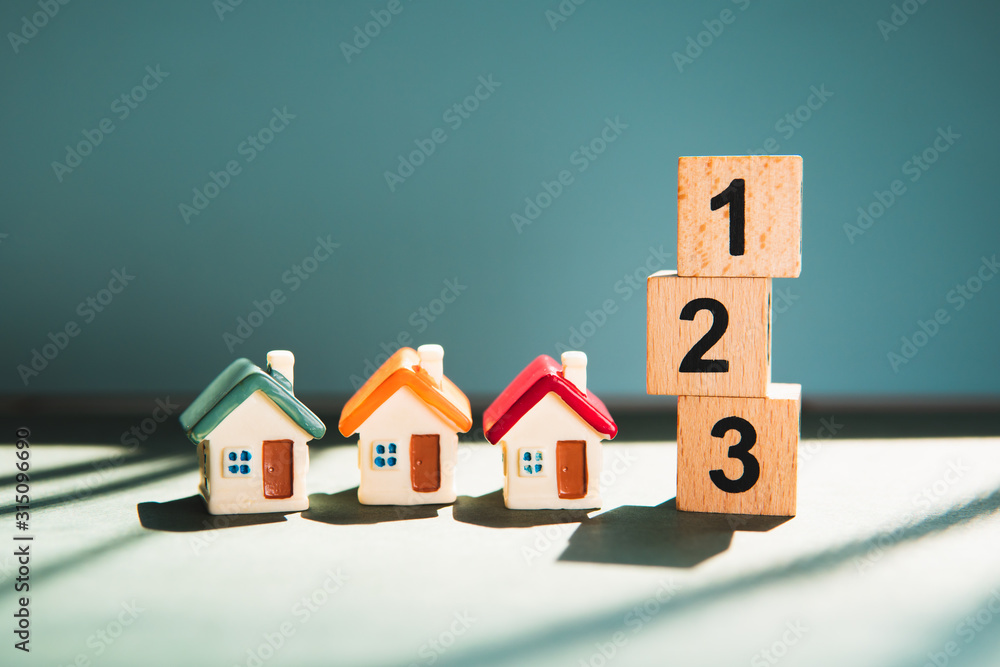 Miniature colorful house with wooden block number using as business and property real estate competition concept Miniature colorful house with wooden block number using as business and property real estate competition concept