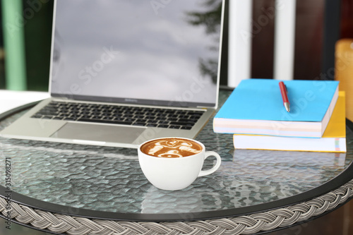 Cups of latte coffee with laptop working in coffee shop