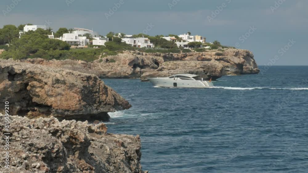 Yacht fährt in eine bucht umgeben von Steilen Felswänden auf Mallorca mit leichter bewölkung Yacht fährt in eine bucht umgeben von Steilen Felswänden auf Mallorca mit leichter bewölkung