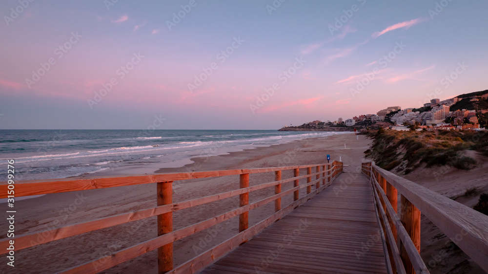 Wild beach with sandy dunes at sunset by the Mediterranean Sea in Valencia Spain