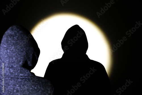 Man silhouette in hoodie. Shadow in the spotlight.