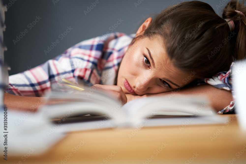 Tired female student learning till late at home Tired female student learning till late at home