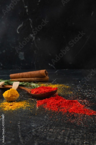 Fototapeta Naklejka Na Ścianę i Meble -  Different types of spices on a dark stone background, view from the top