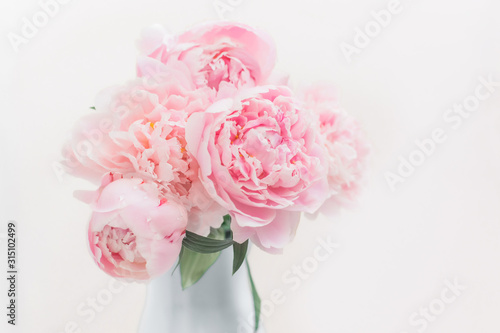 Bouquet of pink peonies in a vase pastel toned.