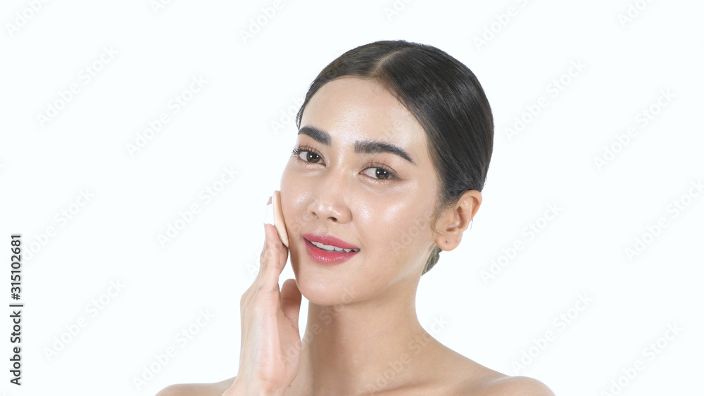 Beauty concept. Beautiful girl is applying foundation on the face on a white background. 4k Resolution.