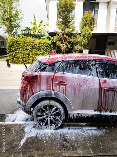 Washing red car with active foam