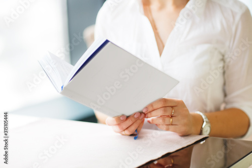 Caucasian business woman in cafe reading book