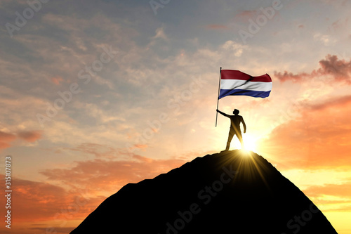 Netherlands flag being waved at the top of a mountain summit. 3D Rendering