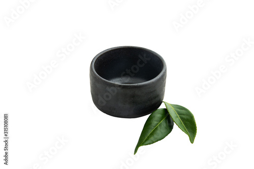 Isolate blank dark bowl with mini green tea leaves on white background.