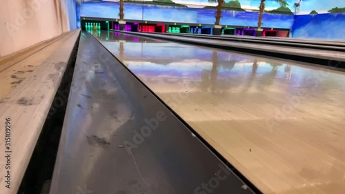 bowling ball rolls and knocks down pins