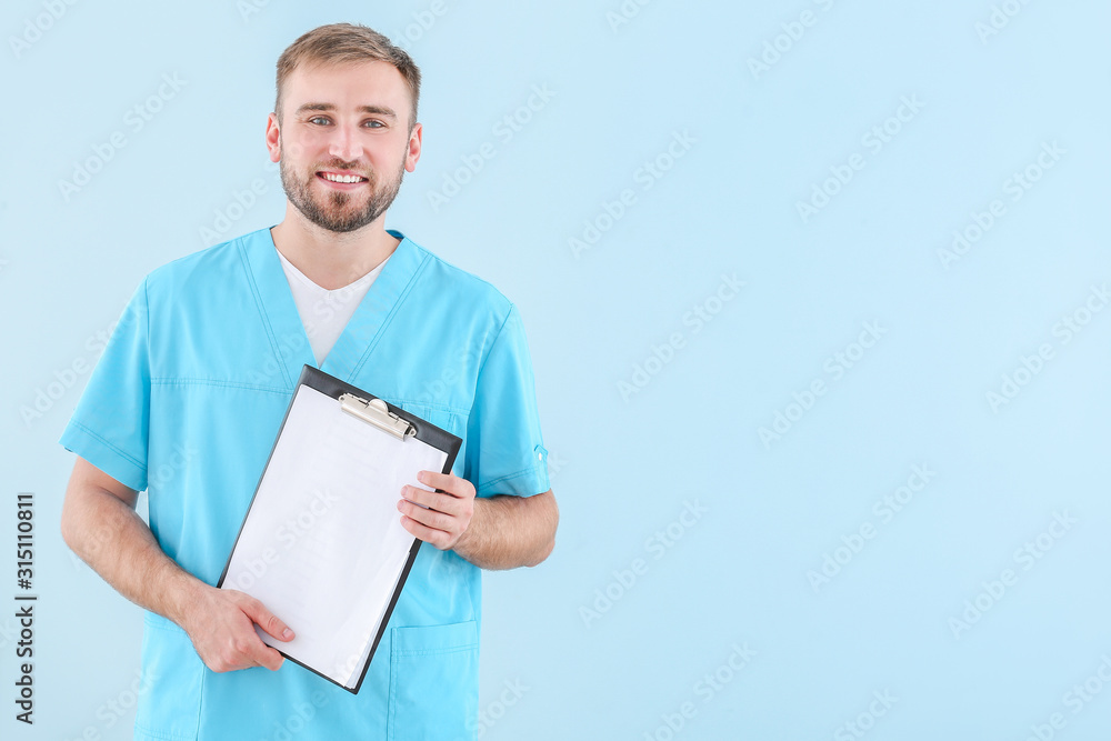 Portrait of male doctor with clipboard on light background Portrait of male doctor with clipboard on light background