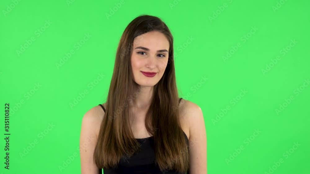 Lovely girl smiles broadly and winks flirting. Green screen Lovely girl smiles broadly and winks flirting. Green screen