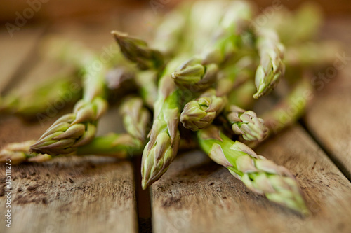 Still life close up fresh, organic, healthy, green asparagus tips on wood photo