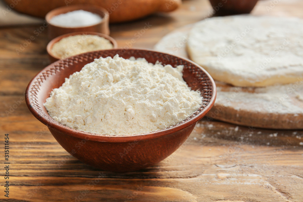 Bowl with flour on wooden table Bowl with flour on wooden table