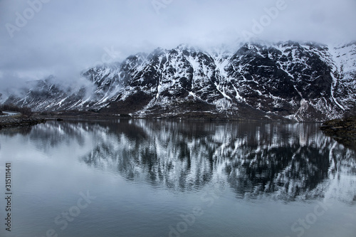Fog over snowy, remote mountains water, Lia, Langoya, Vesteralen, Norway photo