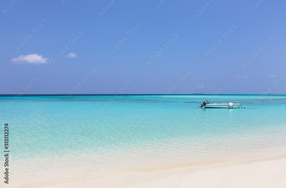 Boat moored in sunny, tranquil ocean, Maldives, Indian Ocean Boat moored in sunny, tranquil ocean, Maldives, Indian Ocean