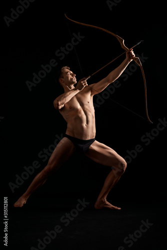 Canvas Print Athletic archer shooting with bow.