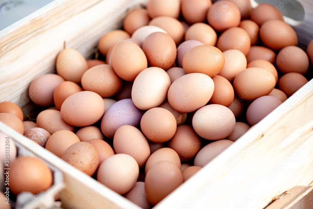 Excellent eggs by fabulous birds. Close up of many fresh organic farm eggs in a wooden box. Organic farming, animal rights, back to nature concept. Horizontal shot Excellent eggs by fabulous birds. Close up of many fresh organic farm eggs in a wooden box. Organic farming, animal rights, back to nature concept. Horizontal shot